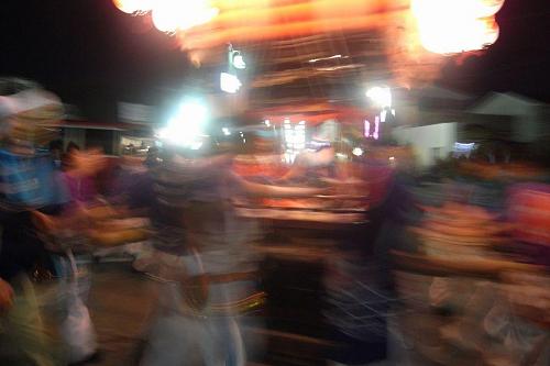 Exciting night festival float with little boys sitting in the float playing a drum